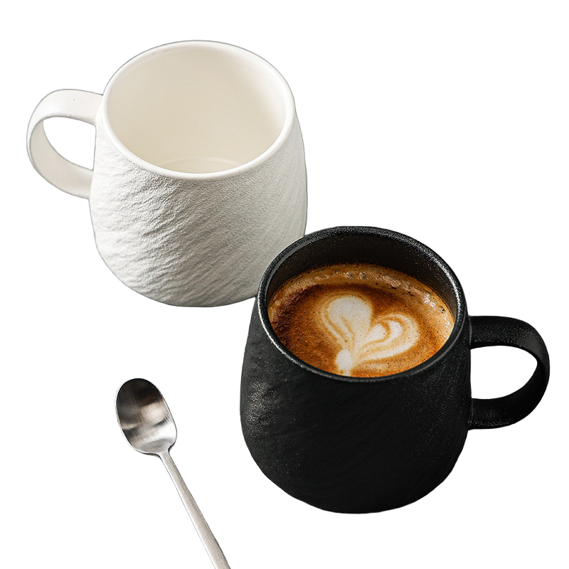 Black and white stone-texture ceramic mugs with coffee and stainless steel teaspoon