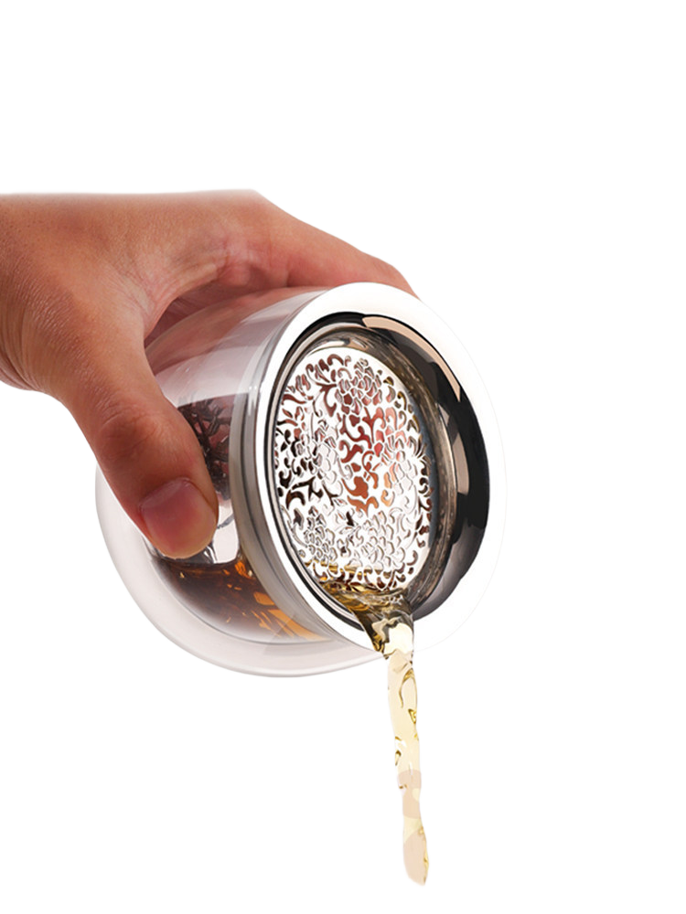 Tea pouring through the fine peony-pattern stainless steel filter of the glass infuser pot