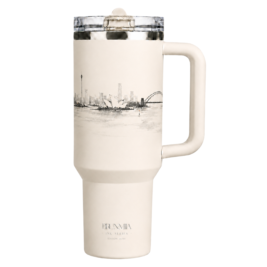 Front view of the BRUNMIIA Ink Series 40oz cream tumbler with side handle, flip-straw lid and monochrome Sydney skyline artwork