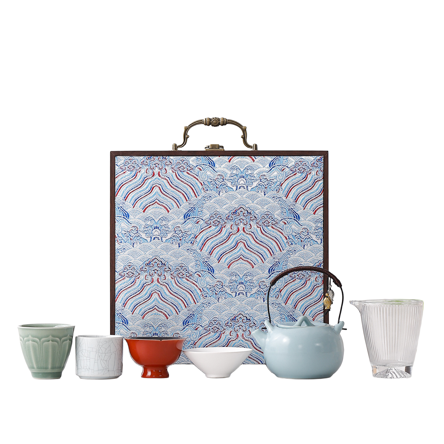 Portable ceramic tea set with four assorted cups, glass pitcher, pale blue teapot and blue wave-pattern hard case
