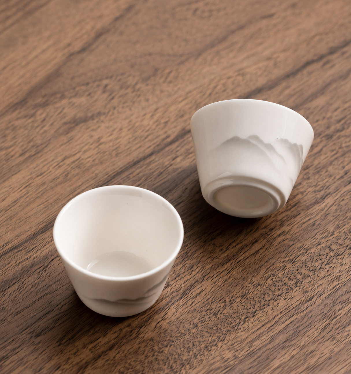 Two white ceramic tea cups with grey mountain motifs from the BRUNMIIA travel tea set